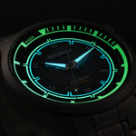 Close-up of glowing Berny watch face with green and blue illumination on a dark background